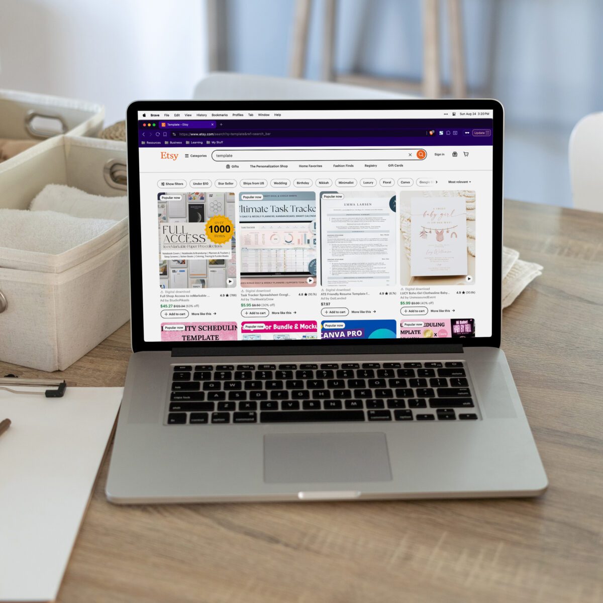 A laptop on a table displays Etsy planner templates on its screen, illustrating a faceless marketing strategy, with baskets in the background.